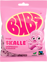 A 90g bag of Faire - Sweet as Fudge Candy: Bubs Sour Foam Raspberry Skulls, a vegan gummy with raspberry flavor. The pink pack features Fairtrade and vegan symbols and a large yellow-pink Bubs logo with a pink skull candy illustration.