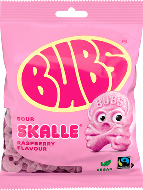 A 90g bag of Faire - Sweet as Fudge Candy: Bubs Sour Foam Raspberry Skulls, a vegan gummy with raspberry flavor. The pink pack features Fairtrade and vegan symbols and a large yellow-pink Bubs logo with a pink skull candy illustration.