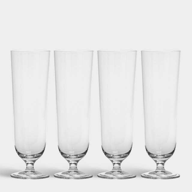 Four empty Orrefors Beer Pils 15.5oz glasses (4-Pack by Erika Lagerbielke) are lined up side by side on a white background.