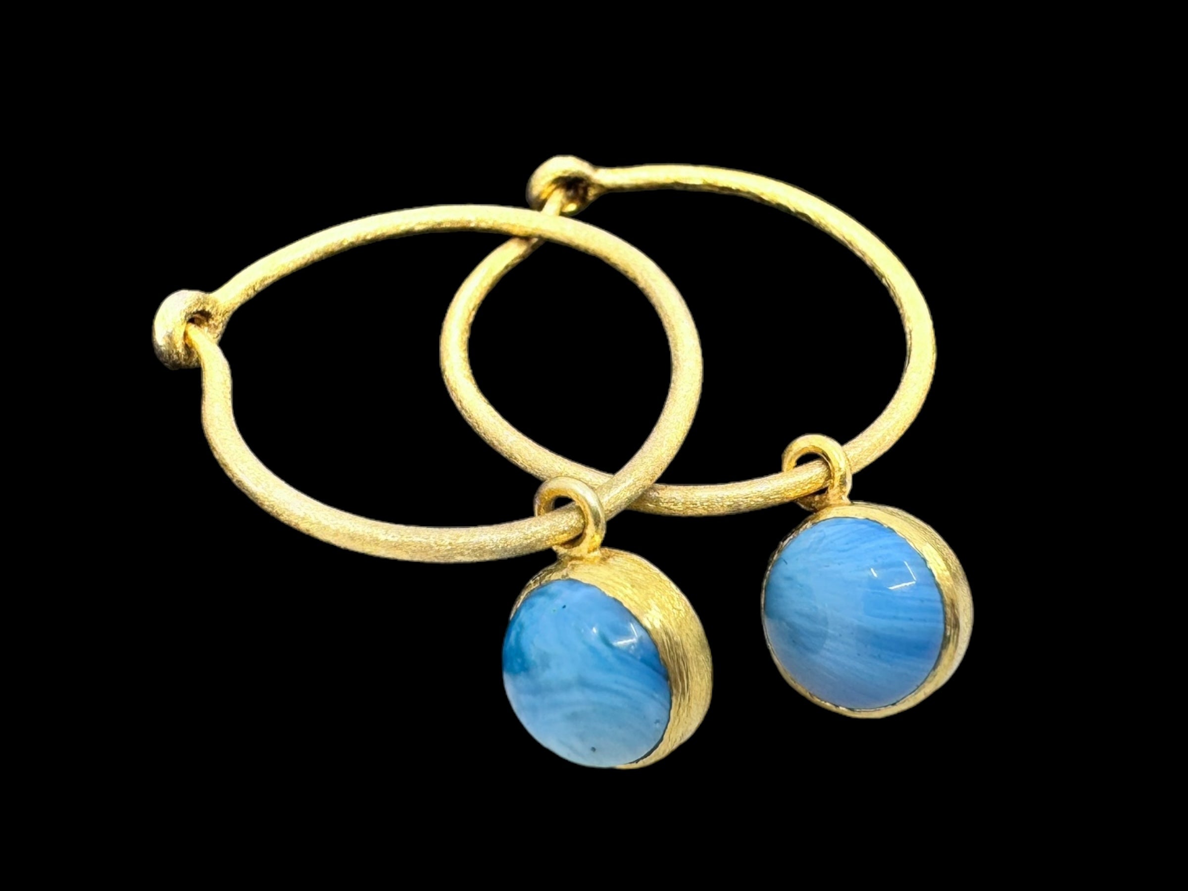 Cirkel Gold earrings feature Swedish Blue stones that elegantly dangle in gold-plated sterling silver.