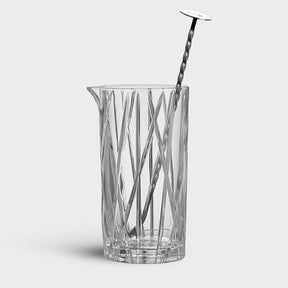 The Orrefors: City Mixing Glass with Spoon 22oz features vertical and diagonal etched lines, reminiscent of Martti Rytkönens elegant design.