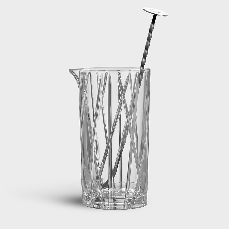 The Orrefors: City Mixing Glass with Spoon 22oz features vertical and diagonal etched lines, reminiscent of Martti Rytkönens elegant design.