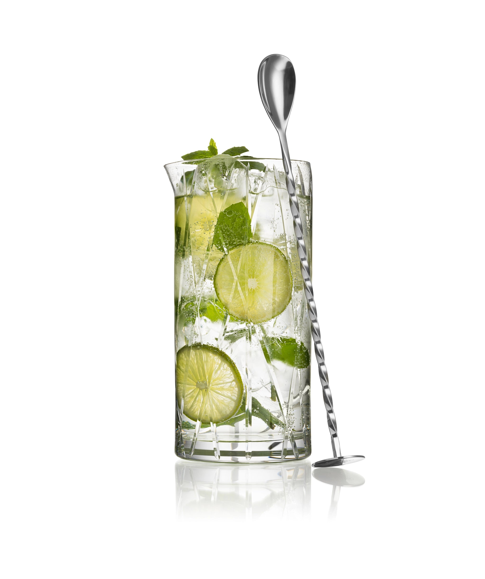 An Orrefors: City Mixing Glass with Spoon 22oz, filled with a mojito featuring lime slices, mint leaves, and ice.