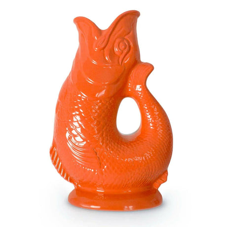The Gluggle Jug Classic, made in Europe, is a bright orange fish-shaped jug with a handle formed by the curved tail—a timeless piece of British tableware.