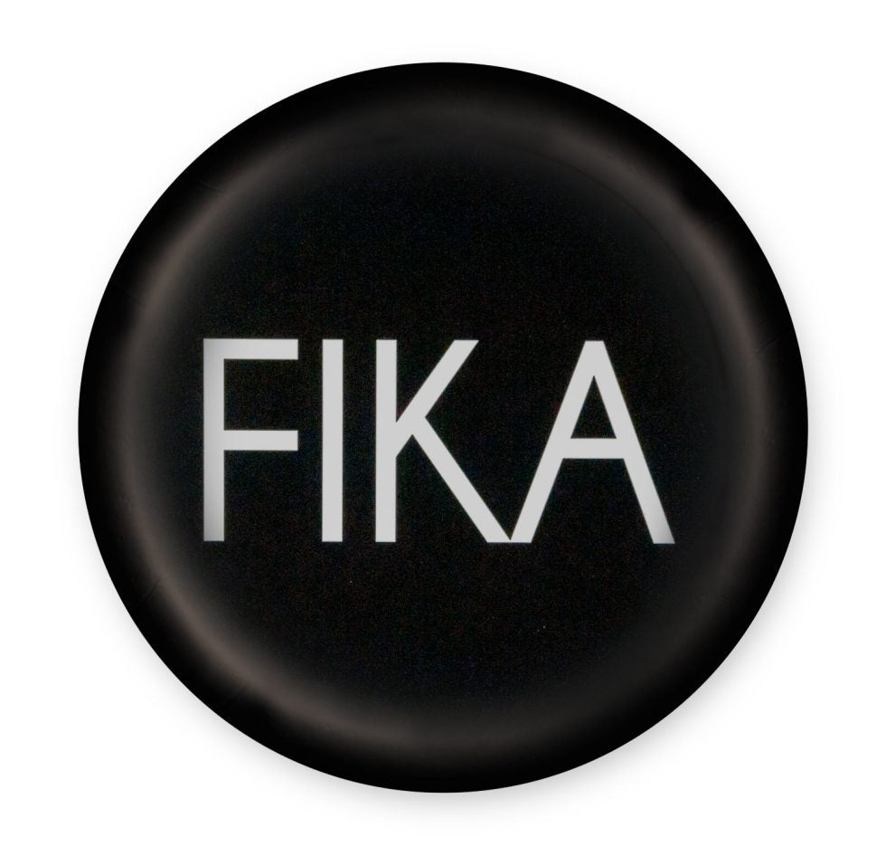 A cozy set of coasters, the Fika Black features a round black design with the word FIKA in bold white letters, capturing the essence of the cherished Swedish tradition during coffee breaks.