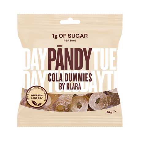 A beige packet of Pandy Sugar Free Sour Cola Dummies candy highlights Scandinavian confectionery innovation, containing only 1g of sugar per bag and boasting a 40% reduction in CO2 emissions.