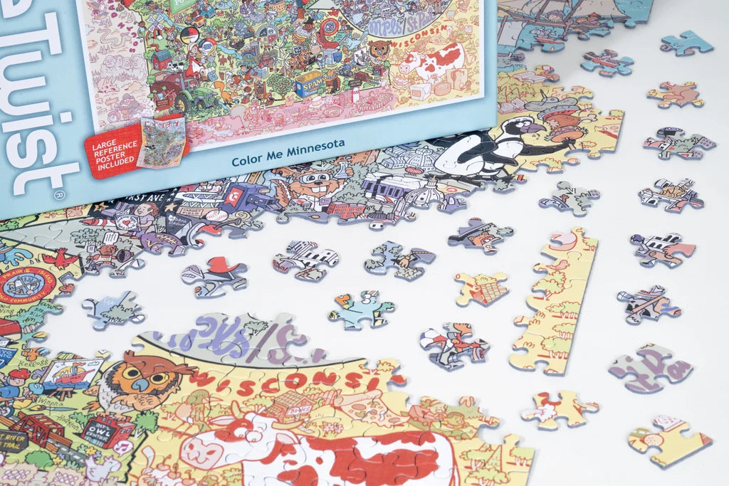 Colorful jigsaw puzzle pieces scattered next to a partially assembled Minnesota-themed puzzle and a box labeled “Color Me Minnesota” with illustrated graphics.