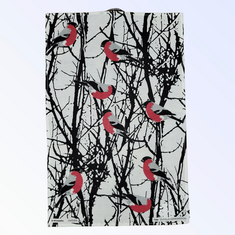 The Tea Towel: Bullfinches in Birch Trees "Domherrar" by Almedahls of Sweden is a rectangular cotton linen kitchen towel featuring black and white birch branches with red and gray bullfinches, inspired by classic Swedish design.