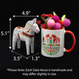 The "Love Horse" Karlekshast 13cm (5") white hand-carved Dala horse, symbolizing Swedish heritage décor, stands beside a mug with a red handle and pink pom-pom flowers; the mug has a 1.3" wide base.