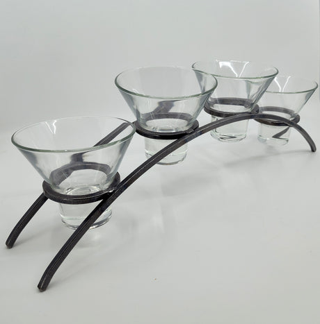 The Danish Iron Arched Candle Holder elegantly supports 4 Leif Cups, perfect for ball candles, on a graceful curved metal stand with two sturdy legs.