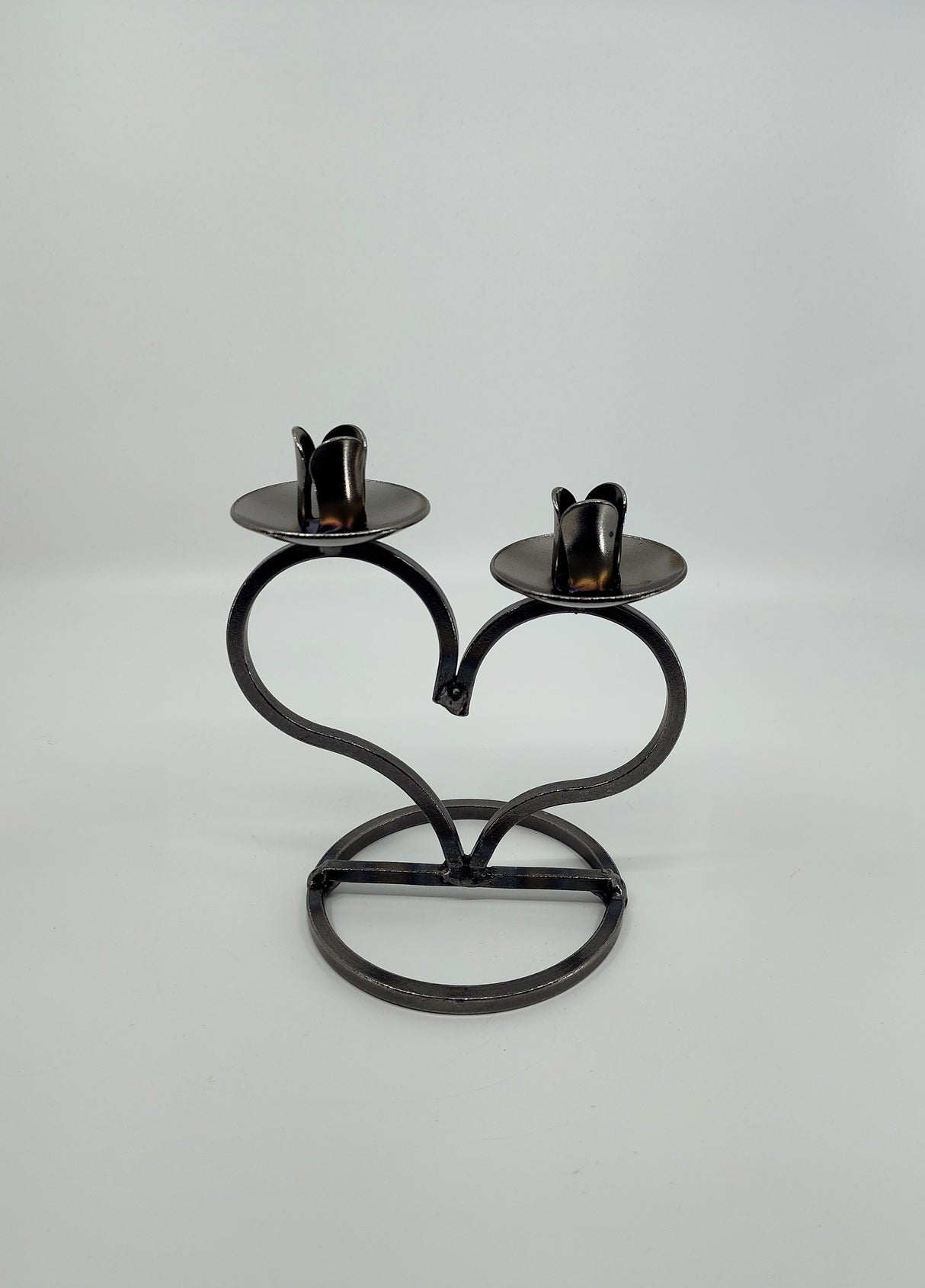 The Danish Iron Taper Candleholder, with a large heart design, elegantly holds two taper candles.