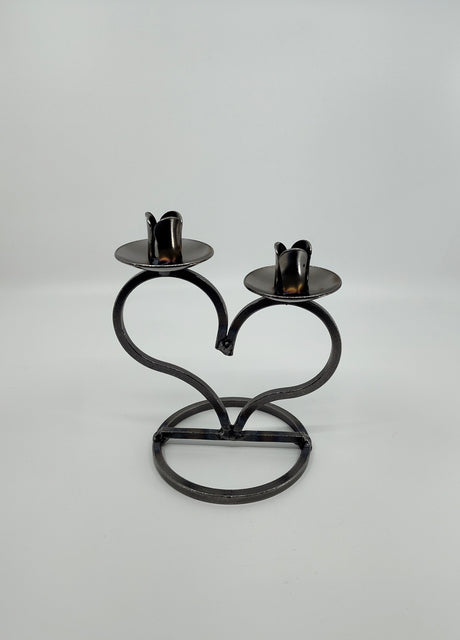 The Danish Iron Taper Candleholder, with a large heart design, elegantly holds two taper candles.