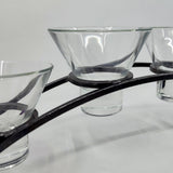 The Danish Iron Arched Candle Holder, featuring four Leif cups, elegantly displays glass candle holders against a plain background.