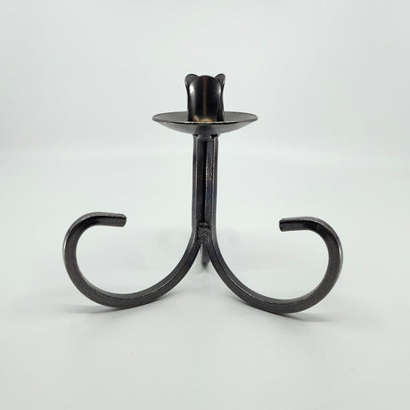 The Candle Holder: Danish Iron Taper Candleholder features a central stem with gracefully curved legs, ideal for a single taper candle.