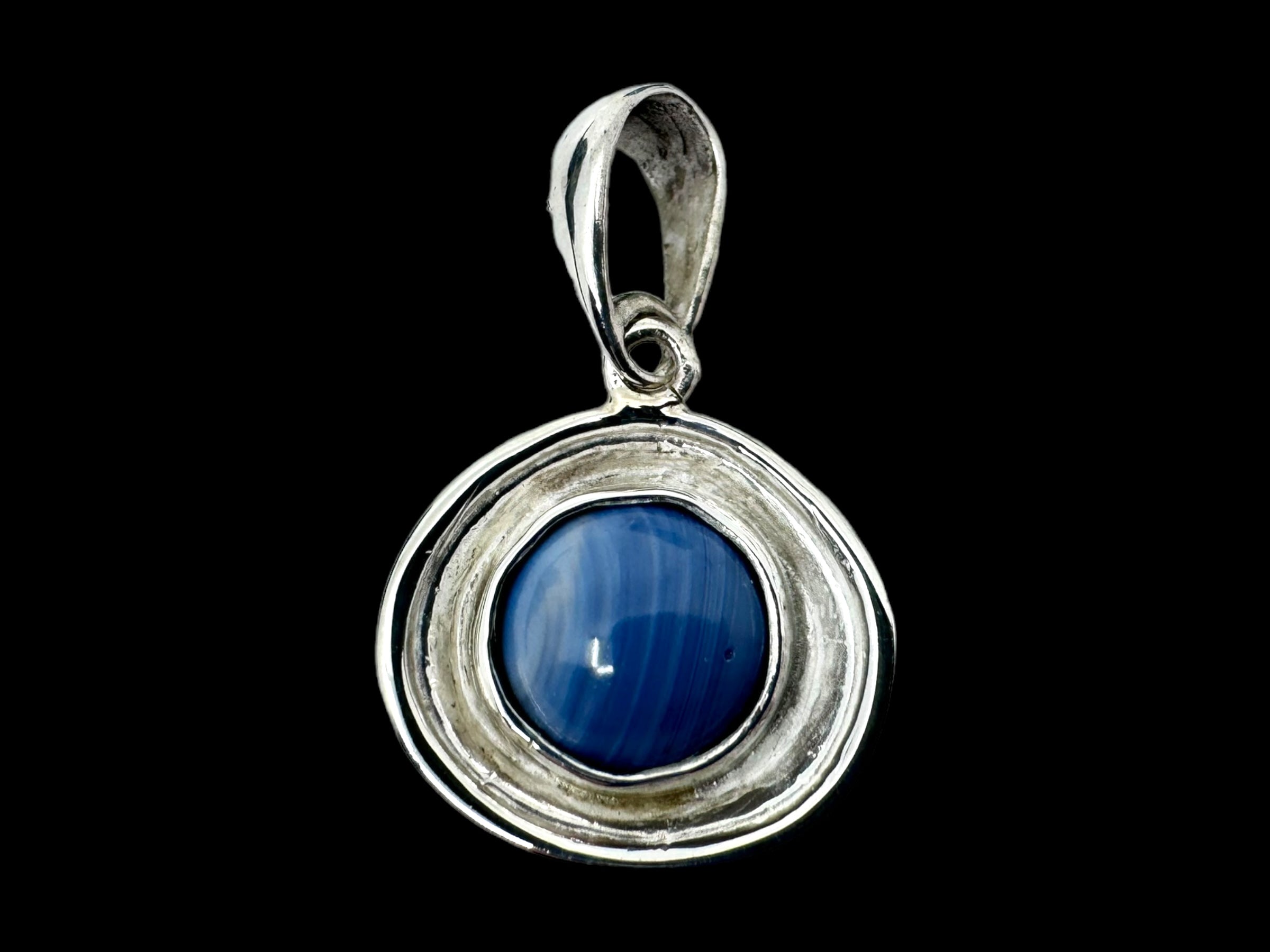 The Eira Silver pendant, crafted with .925 silver, features a mesmerizing Swedish Blue stone at its center, beautifully set against a sleek black background.