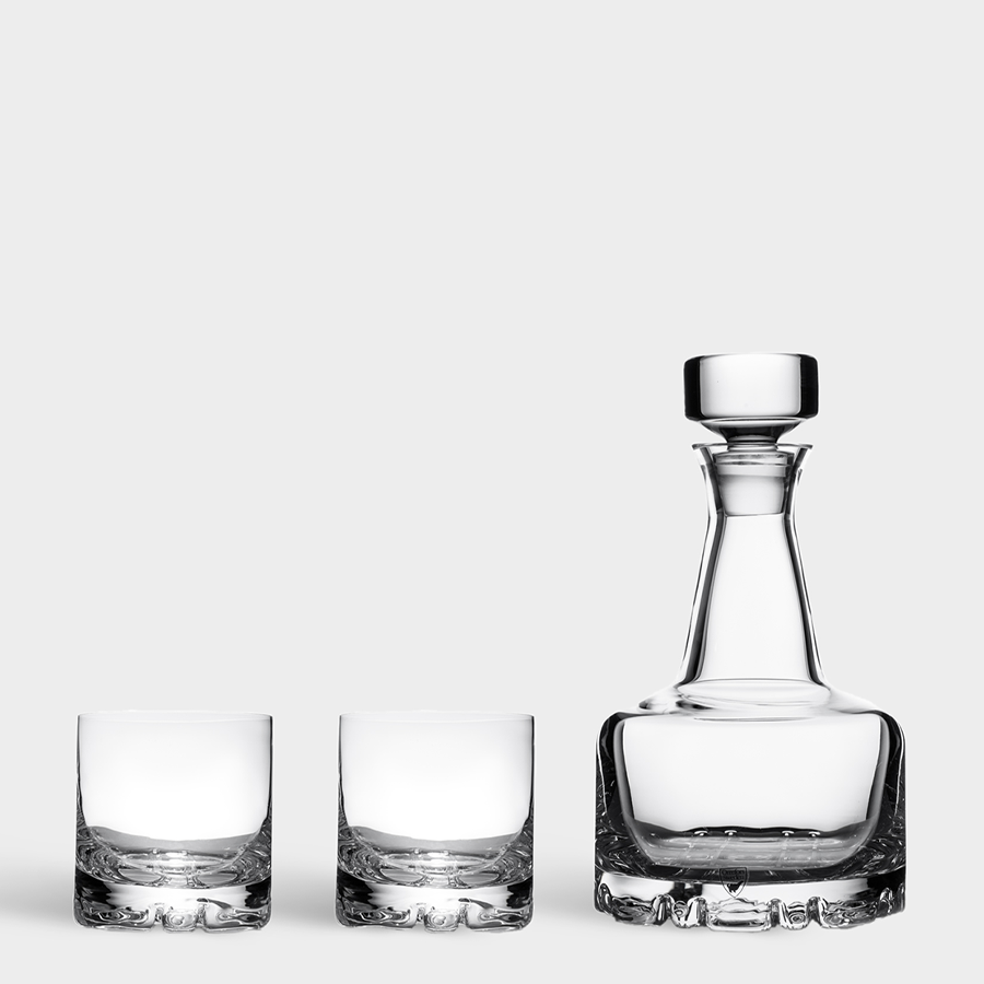 The Orrefors: Erik 3 Piece Set includes a sleek 26oz decanter with a stopper, elegantly paired with two clear double old fashioned glasses, all displayed on a plain white background.