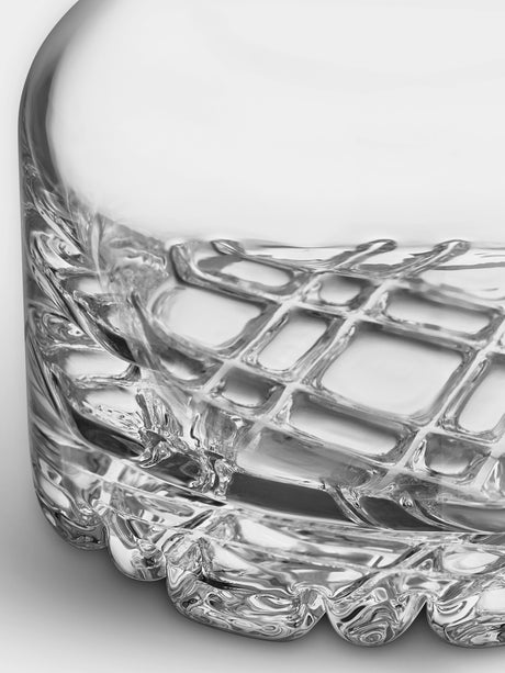 Close-up of the bottom part of the Orrefors Erik 3-Piece Set—26oz decanter and two 12oz double old fashioned glasses—showing a clear glass with textured, crisscross pattern and scalloped edge inspired by classic Scandinavian design.