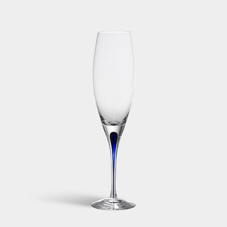 Against a plain white background, the Orrefors Intermezzo Blue Flute 7oz by Erika Lagerbielke stands elegantly with its slim blue accent on the stem.