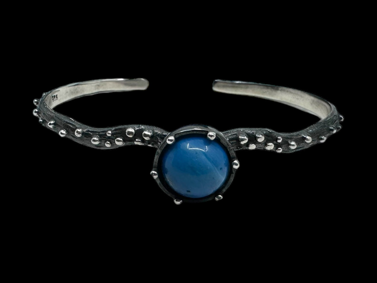 The Freja Thin bracelet features an oxidized silver textured band with a captivating Swedish Blue ball at its center.