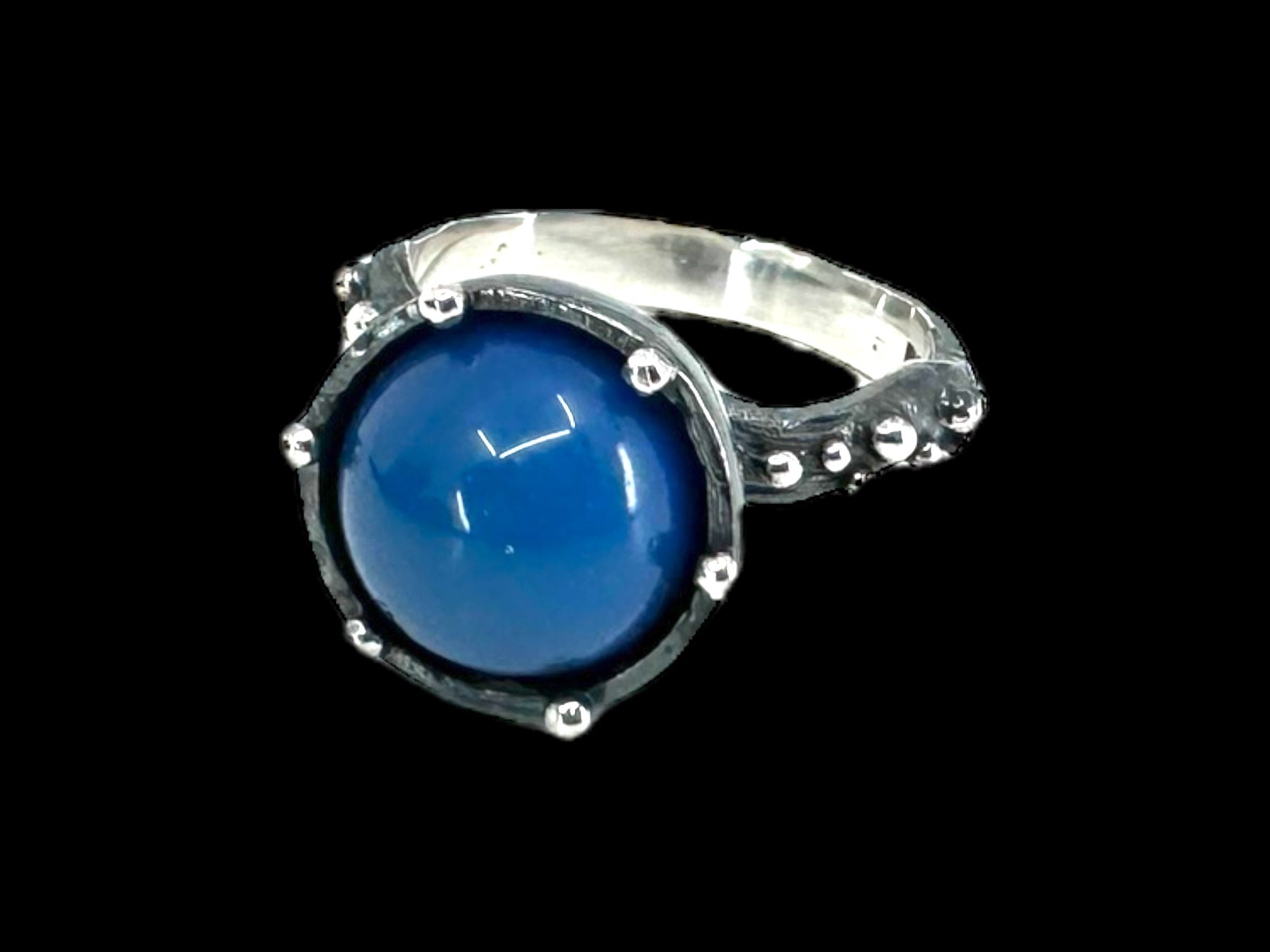 Freja Thin - Swedish Blue ring, showcasing a round Swedish blue ball gemstone, set in a textured and oxidized silver band against a black backdrop.