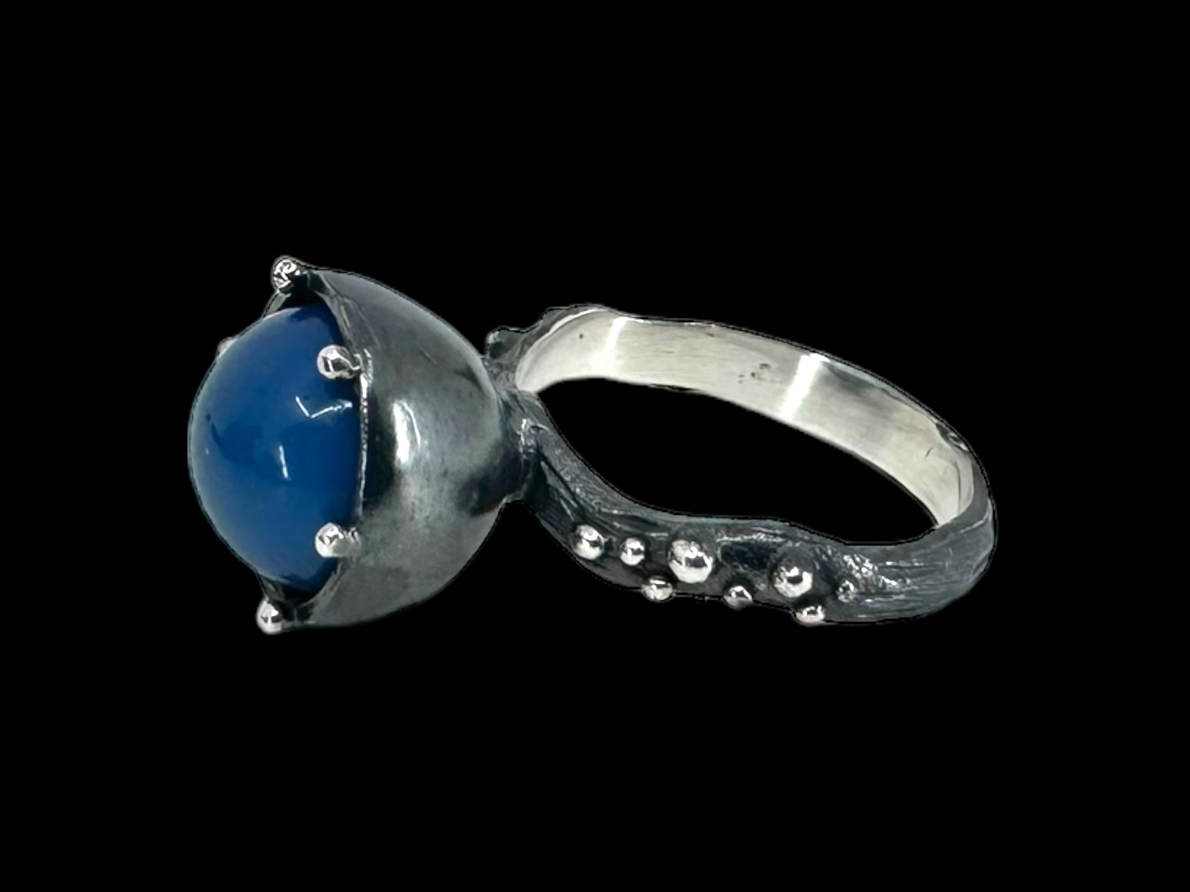 The Freja Thin - Swedish Blue ring features a sleek silver band that highlights a prominent round Swedish blue orb, elegantly set in an elevated bezel and adorned with intricate metal accents.