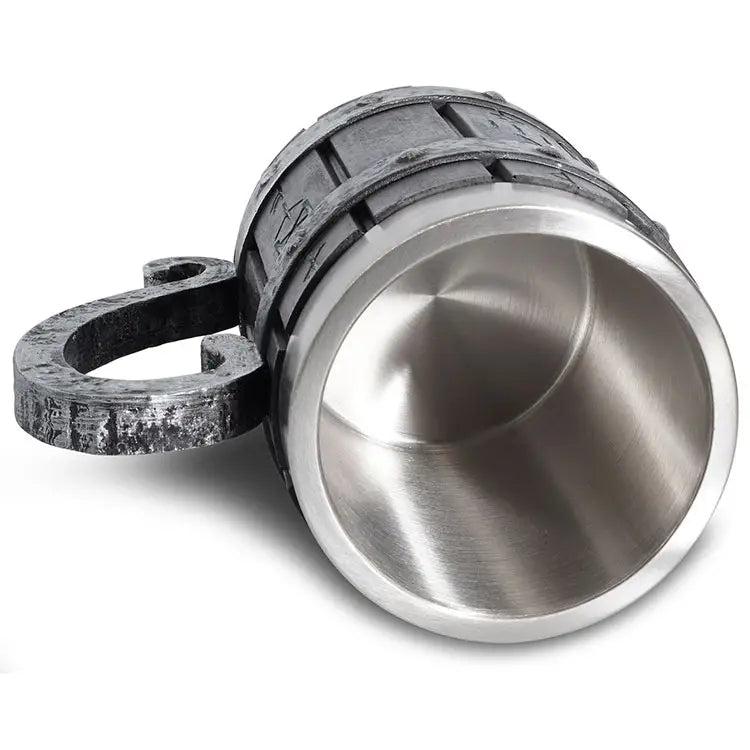 A Runic Viking Barrel Mug (20oz) featuring a textured barrel-like resin exterior and a large circular handle is tilted on its side, unveiling the smooth stainless steel interior.