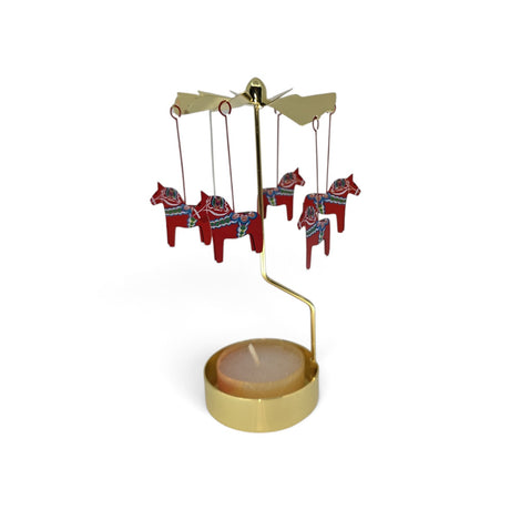 Gold-tone metal Dala horse candle holder with hanging red ornaments featuring blue and green rosemaling patterns that rotate when lit.