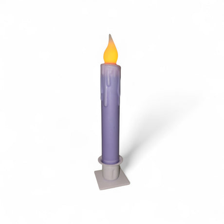 A purple Hand-Dipped Beeswax 7" Tapered LED Light Candle with a yellow flame sits in a white square holder against a plain white background.
