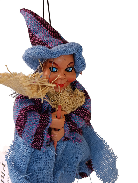 The Kitchen Witch: Philippa Blue Kitchen Witch Doll, handmade in Germany, wears a pointed hat and blue-purple clothes, holds a broom, and hangs by black strings—a charming good luck charm for your home.