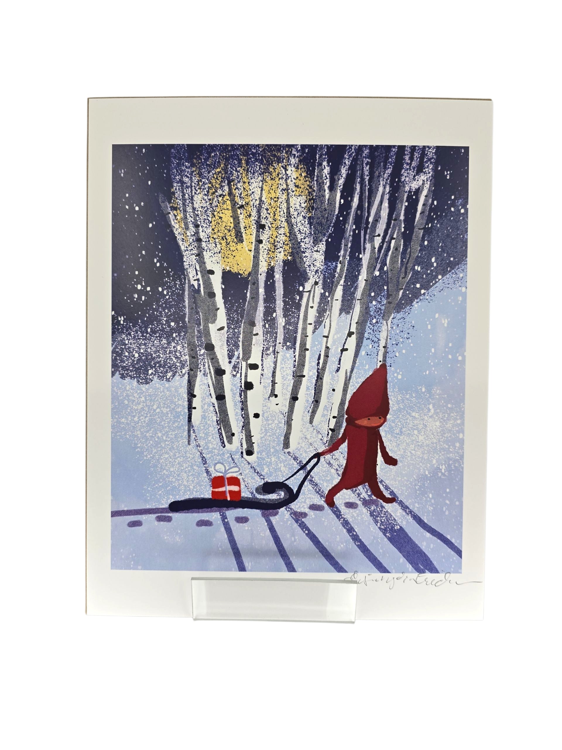 Artwork: Tomten in the Forest Pulling a Sled by Lisa Rydin Erickson (8x10 print) features a red-hooded figure with a sled and gift in a snowy midnight forest, perfect for cozy Swedish holiday decor.