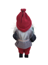 The "Figurine: Santa with Glittering Tree" features a Swedish-inspired Santa doll with white hair, red hat, gray vest, black shirt, and red pants—seen from the back against a white background. Makes a unique Christmas tree decoration.