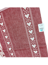 Redlunds of Sweden’s "Kajsa Lopare" table runner is a 14" x 47" red and white woven cotton piece, featuring two rows of white hearts along the edges. A price tag remains attached to the upper right corner.