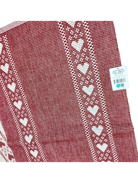 Redlunds of Sweden’s "Kajsa Lopare" table runner is a 14" x 47" red and white woven cotton piece, featuring two rows of white hearts along the edges. A price tag remains attached to the upper right corner.