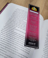 The Bookmark: Swedish Proverbs “Everyday Wisdom” (2.5" × 8.5") rests on an open book, displaying proverbs and translations, capturing Scandinavian tradition on a wooden surface.