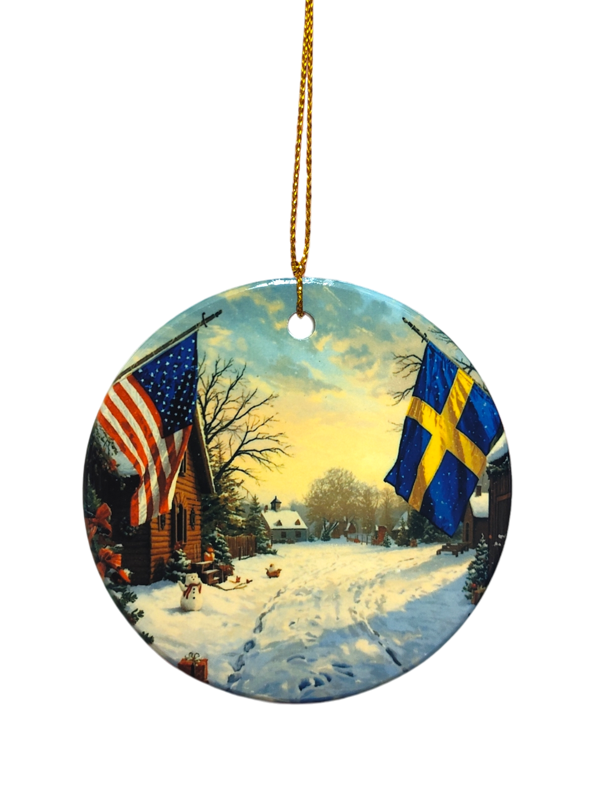 The Ornament: Wooden Village Ceramic Ornament with USA & Sweden Flags features a snowy village scene and hangs from a gold string—ideal for Scandinavian Christmas décor.