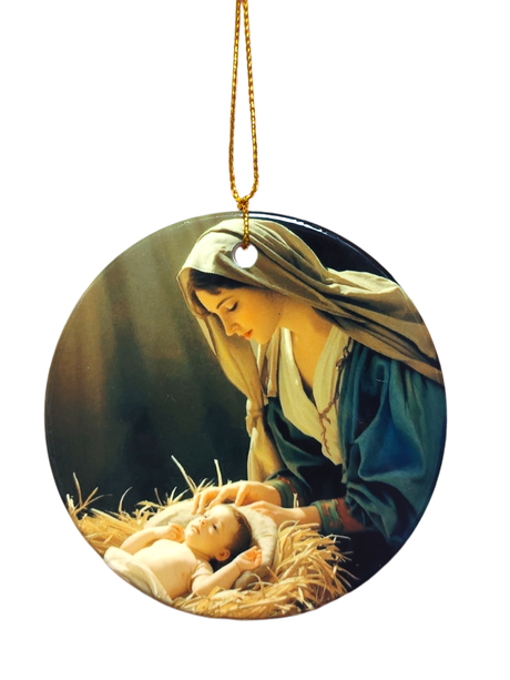 The Ornament: Nativity Scene Ceramic Ornament features a painting of a woman in a headscarf gazing at an infant on straw, with a gold hanging string—an elegant faith-inspired Christmas décor piece.