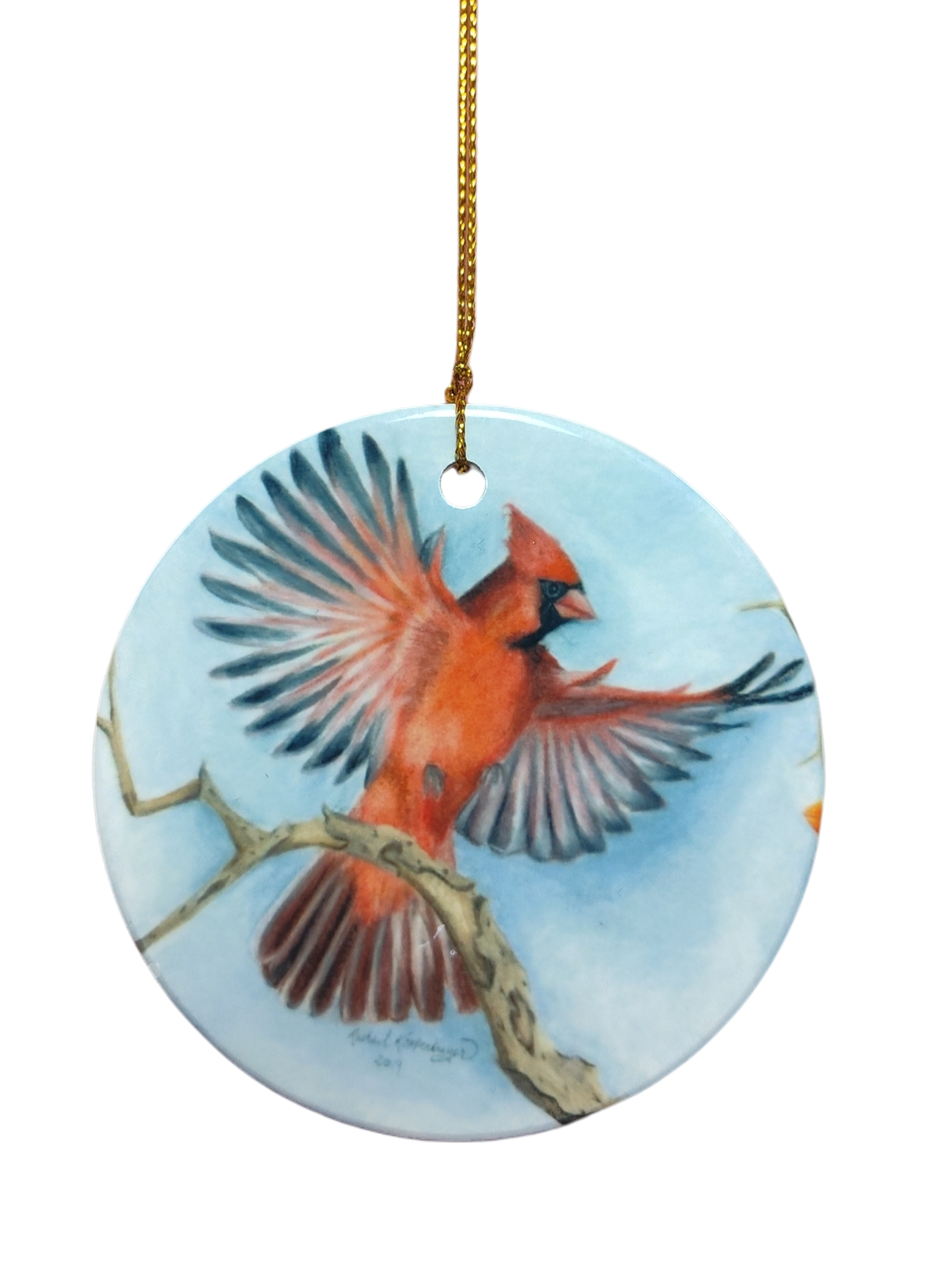 Ornament: Red Cardinal Ceramic Ornament with a painted cardinal in flight above a branch and gold hanging string. A charming gift for bird lovers.