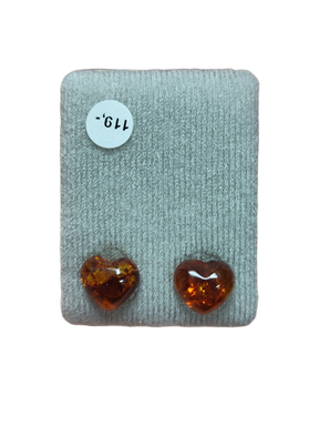 Two polished, heart-shaped amber stones rest on gray fabric beside a white "119" sticker, ideal for making Earrings: Heart-Shaped Amber Stud Earrings.