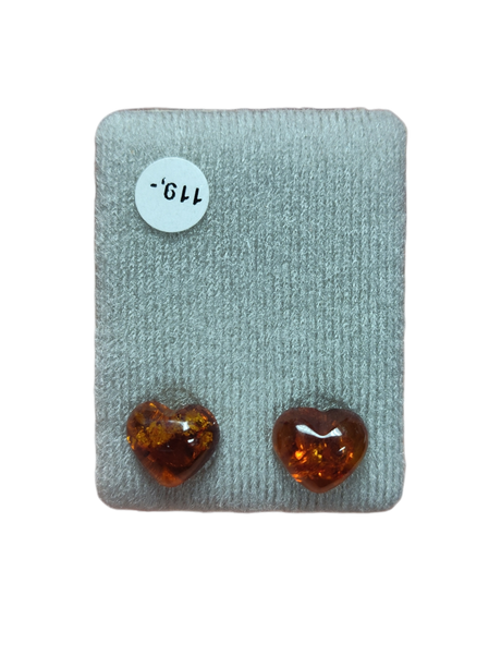 Two polished, heart-shaped amber stones rest on gray fabric beside a white "119" sticker, ideal for making Earrings: Heart-Shaped Amber Stud Earrings.