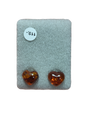 Two polished, heart-shaped amber stones rest on gray fabric beside a white "119" sticker, ideal for making Earrings: Heart-Shaped Amber Stud Earrings.