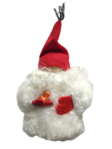 A sheepskin Tomte gnome figurine wearing a red hat and mittens, holding a heart—perfect as charming Swedish table decor.