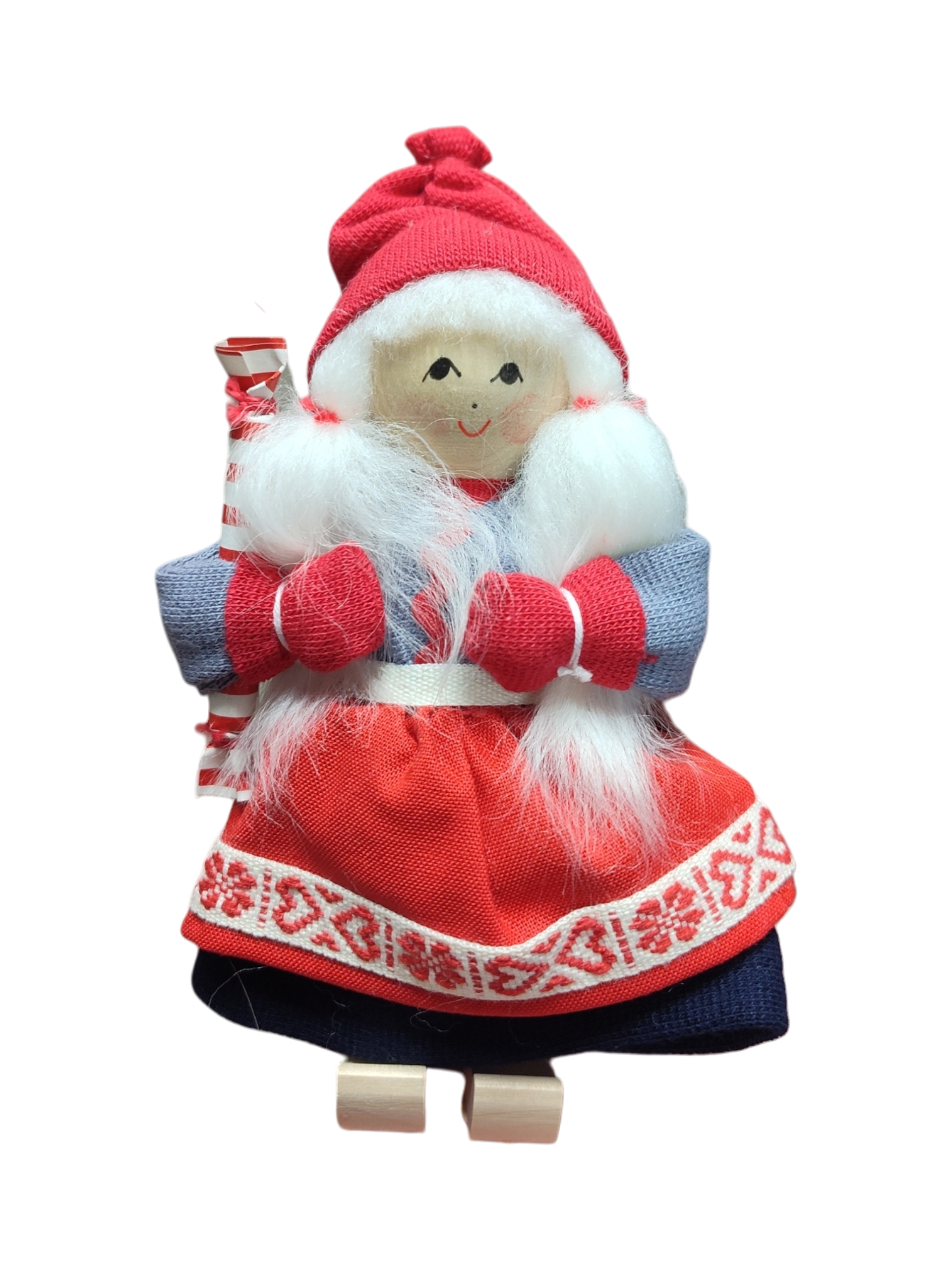 The Figurine: Santa Girl in Traditional Holiday Dress Carrying a Candy-Cane Striped Package features a handcrafted Swedish design—white hair, red mittens and hat, blue and red dress—a charming addition to your Scandinavian Christmas décor.