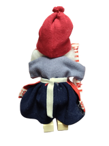 The Figurine: Santa Girl in Traditional Holiday Dress Carrying a Candy-Cane Striped Package features a handcrafted Swedish Santa girl in festive attire—an enchanting accent for Scandinavian Christmas décor.