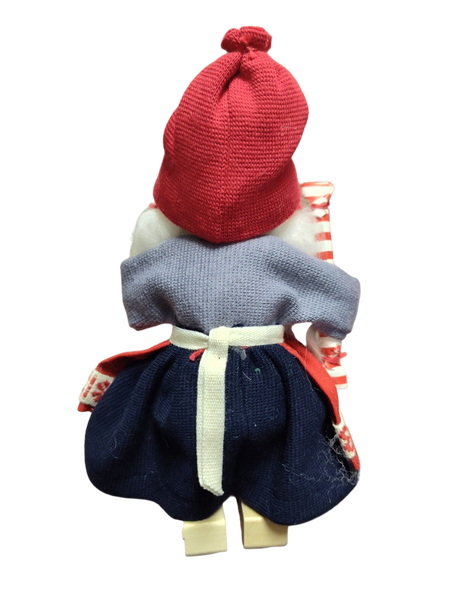The Figurine: Santa Girl in Traditional Holiday Dress Carrying a Candy-Cane Striped Package features a handcrafted Swedish Santa girl in festive attire—an enchanting accent for Scandinavian Christmas décor.
