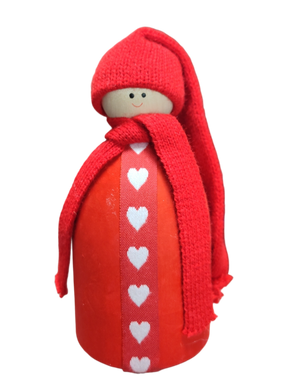 The Santa Figurine with Red Hat features a wooden doll adorned with a red knit hat and scarf and a white heart pattern, adding charming Scandinavian Christmas flair to your holiday table decor.