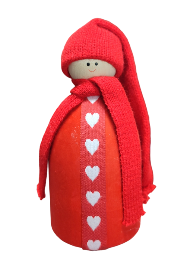 The Santa Figurine with Red Hat features a wooden doll adorned with a red knit hat and scarf and a white heart pattern, adding charming Scandinavian Christmas flair to your holiday table decor.