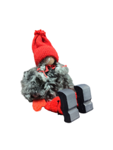 The Sitting Santa Girl Figurine features a red knit hat, red mittens, gray fuzzy coat, and black wooden shoes—handmade in Sweden and perfect as charming Christmas décor.