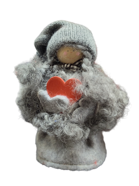 The Figurine: Santa Girl with Heart is a small, handmade Swedish decoration featuring a gray knitted hat, fuzzy gray clothes, and a red heart—perfect for adding Scandinavian charm to your décor.