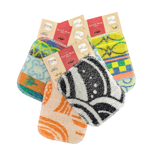 Four vibrant Scrub: Kitchen Scrubber Scrub-Wow pads in assorted patterns and packaging, overlapping on a white background. Safe for Teflon cookware and easy to clean.