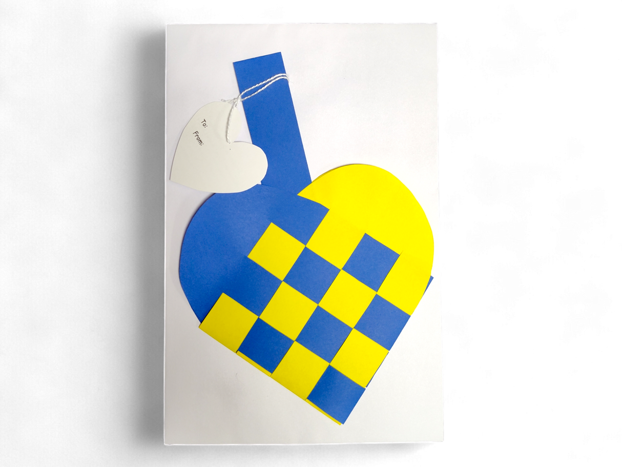 A Card: Swedish Flag Traditional Scandinavian Handwoven Paper Basket Heart with a heart-shaped tag attached by string, shown on a white background.